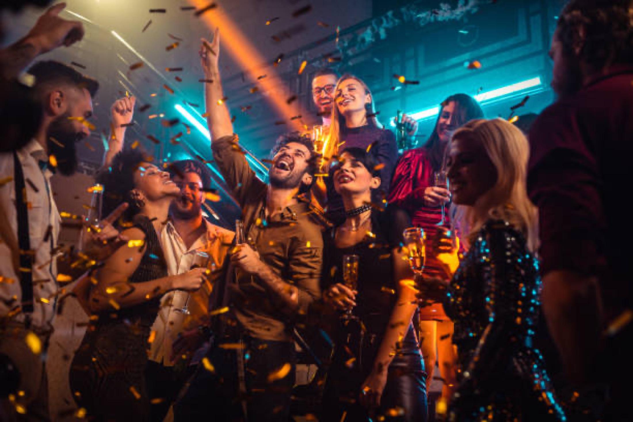 Guests dancing under colourful event lighting