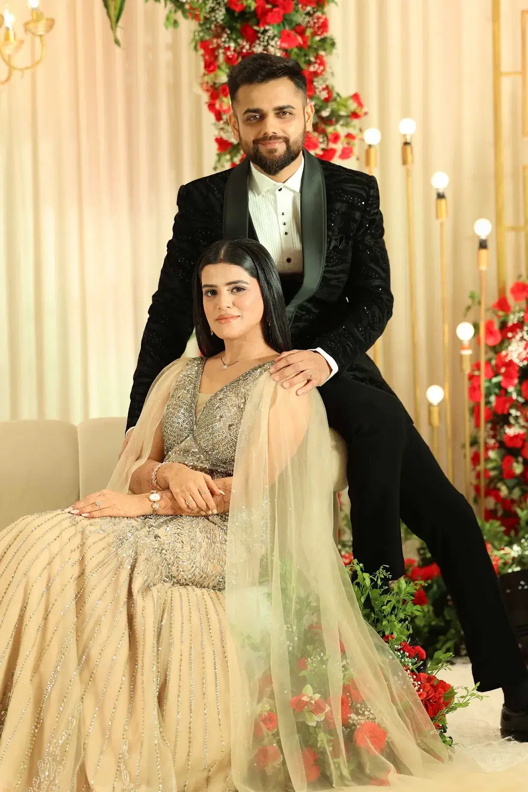 Elegant couple portrait with warm gold decor and red florals