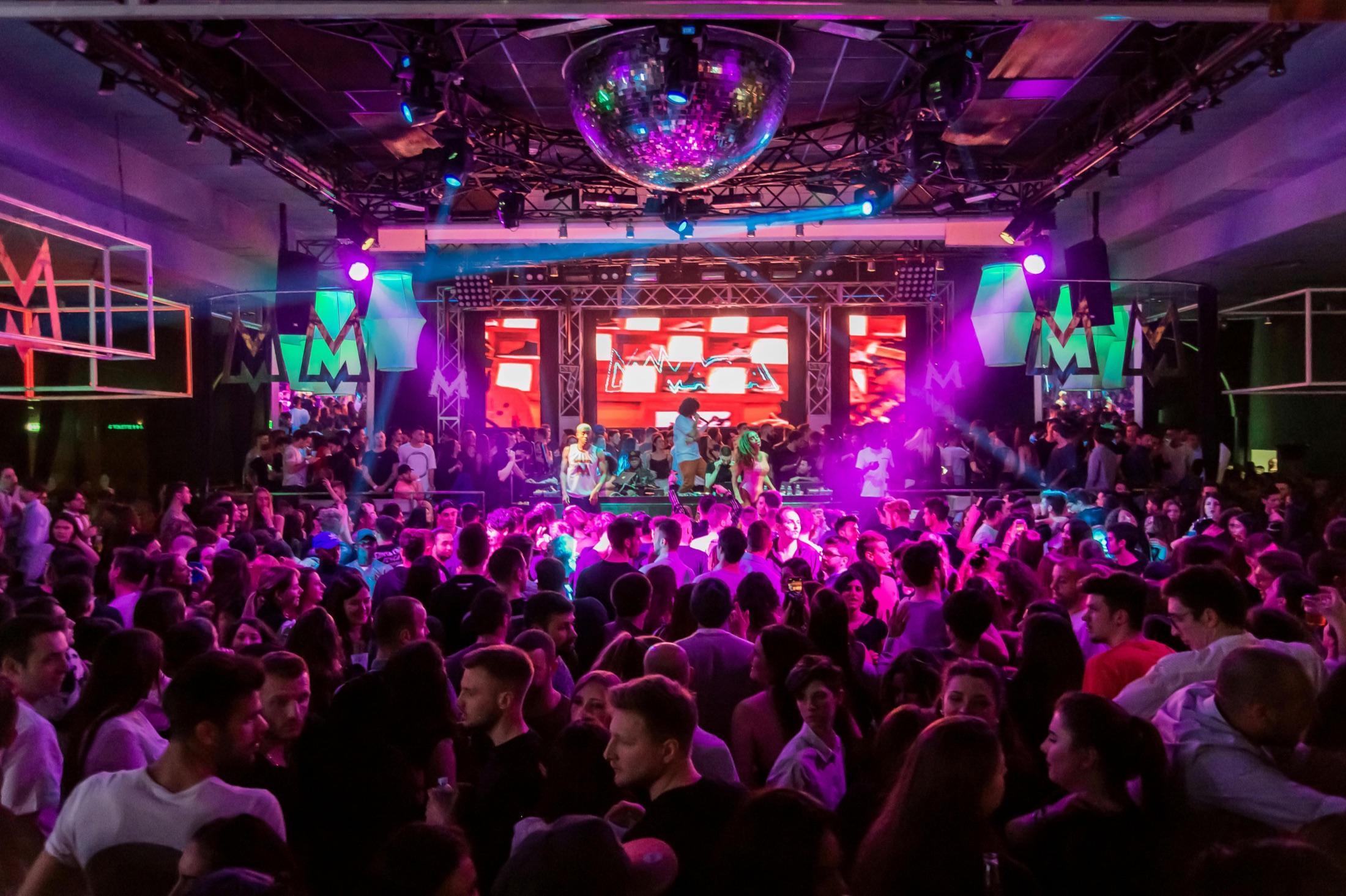 An event crowd beneath vivid stage lights