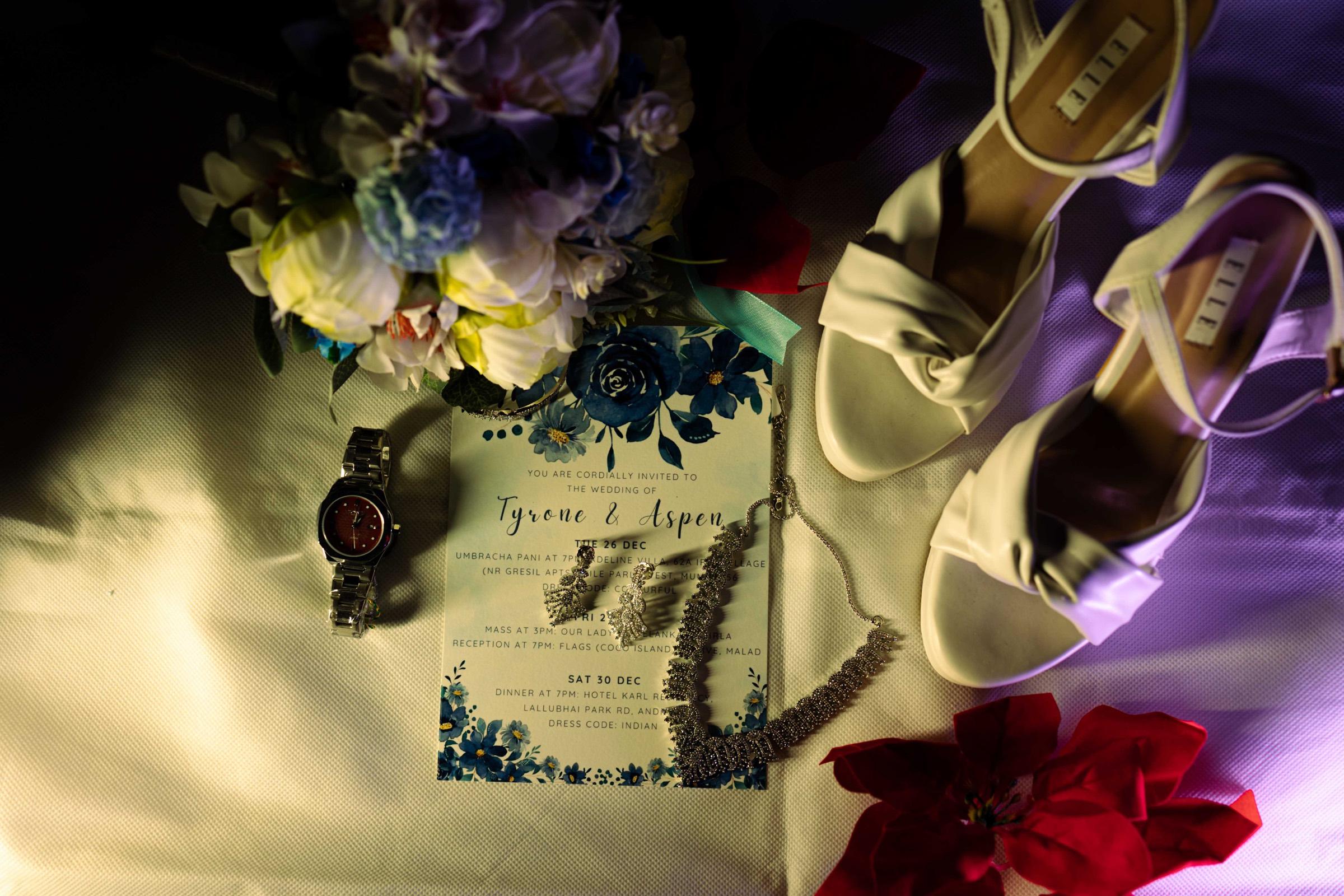 Wedding shoes, invitation and flowers arranged before the celebration